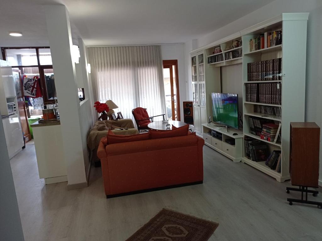 sala de estar con sofá rojo y TV en Nice room-Terrace- Private toilete-Closer Sport Pier-Optical Fiber 1 GB, en Las Palmas de Gran Canaria