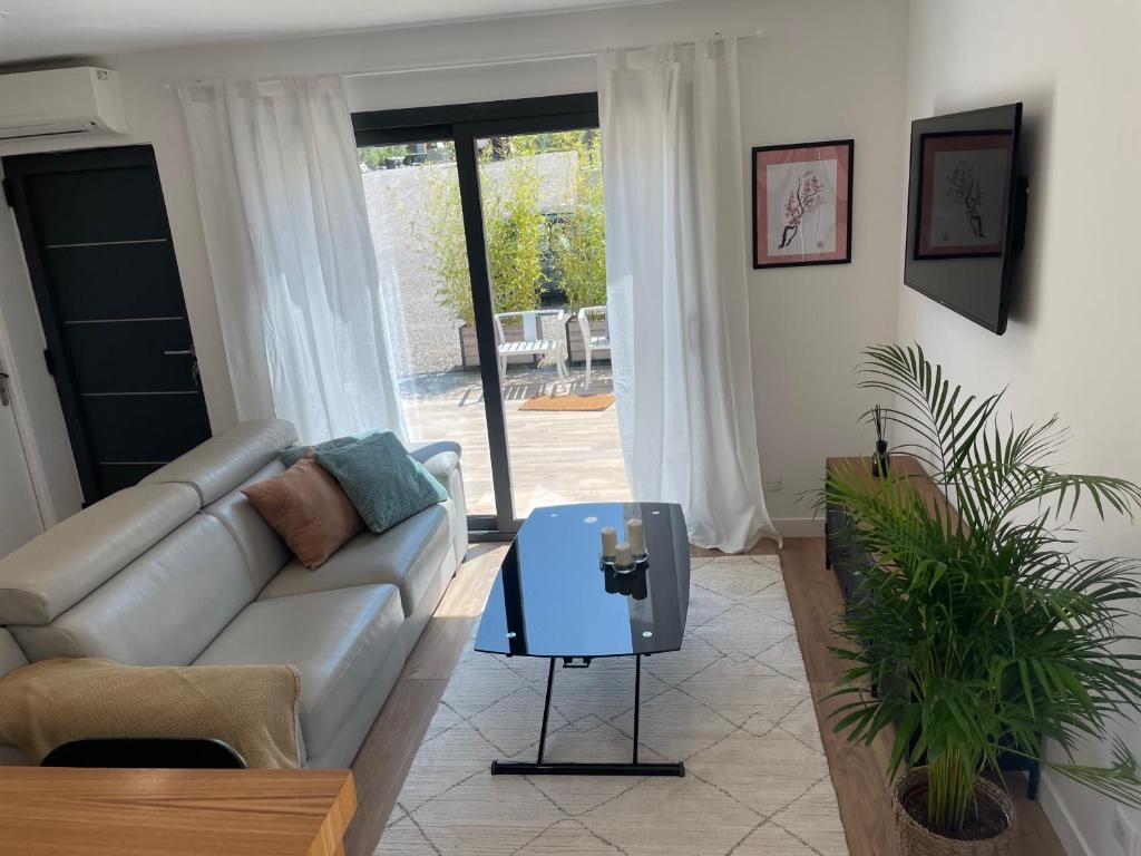 un soggiorno con divano e tavolo di Villa-jacuzzi-1chb-jardin-10minsAixEnPce-QuartierChic a Meyrargues