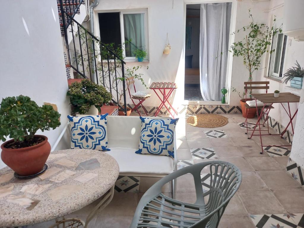 a patio with a table and chairs and a staircase at Guesthouse Jazmínes Mozárabes # WIFI in Baena