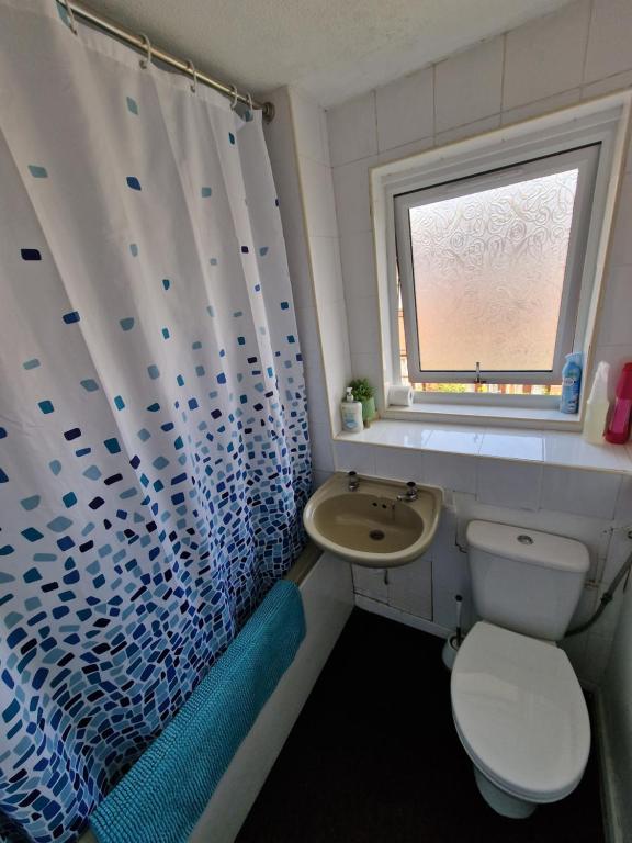 a bathroom with a toilet and a sink and a window at COZY DOUBLE BEDROOM IN ZONE 1-2 CENTRAL LONDON in London