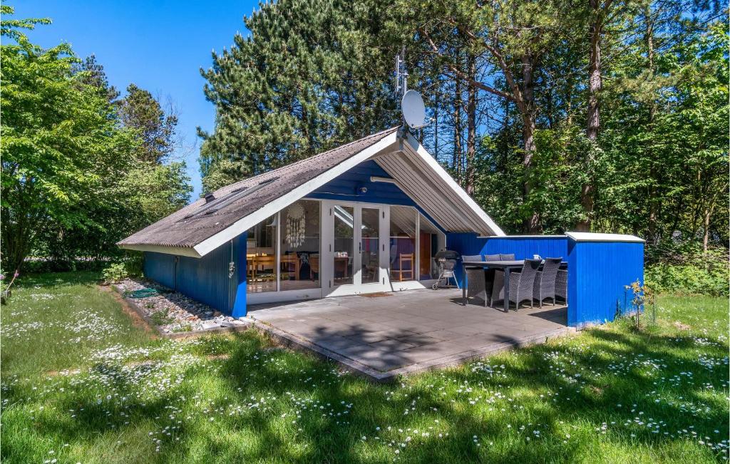 una pequeña casa azul con una mesa en un campo en Beautiful Home In Sams With Kitchen en Nordby