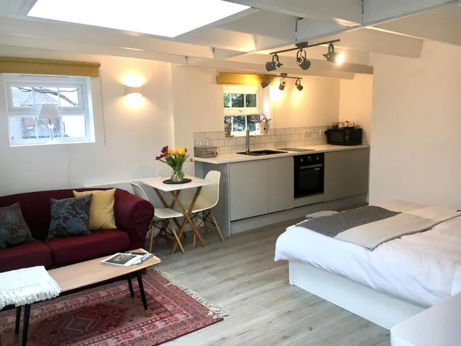 a living room with a couch and a kitchen at Brighton Boutique Garden Studio with Free Parking in Brighton & Hove