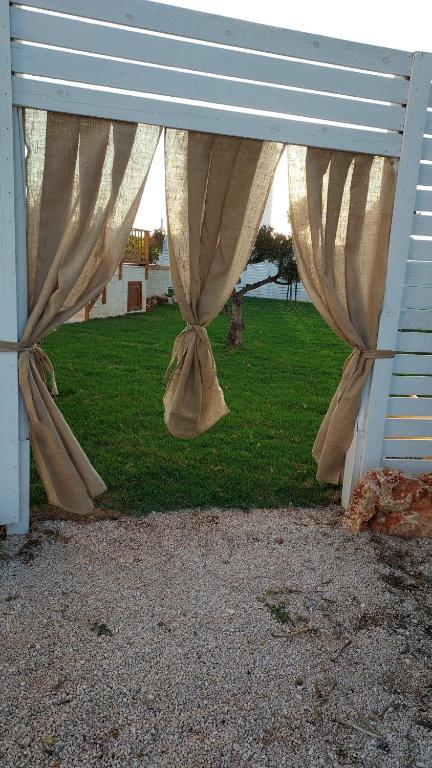 a blue bench with curtains in a yard at Villa Capitani in Torre Canne