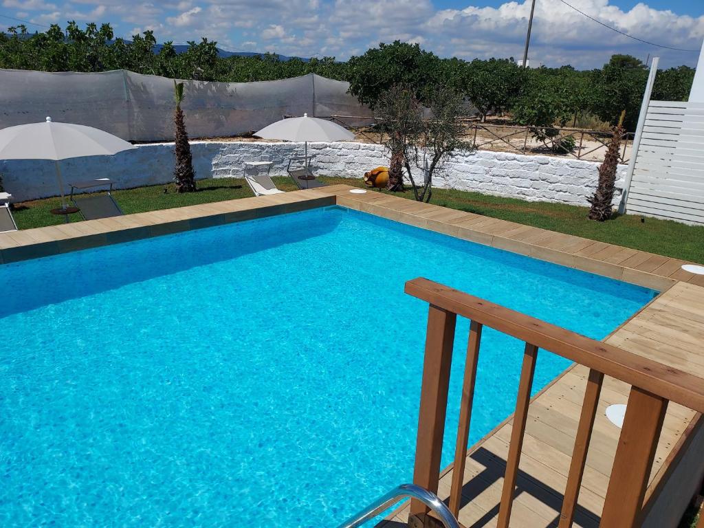 a large blue swimming pool next to a house at Villa Capitani in Torre Canne