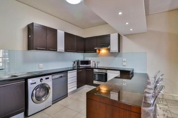 a large kitchen with a washer and a dishwasher at Luxury joy in Cape Town