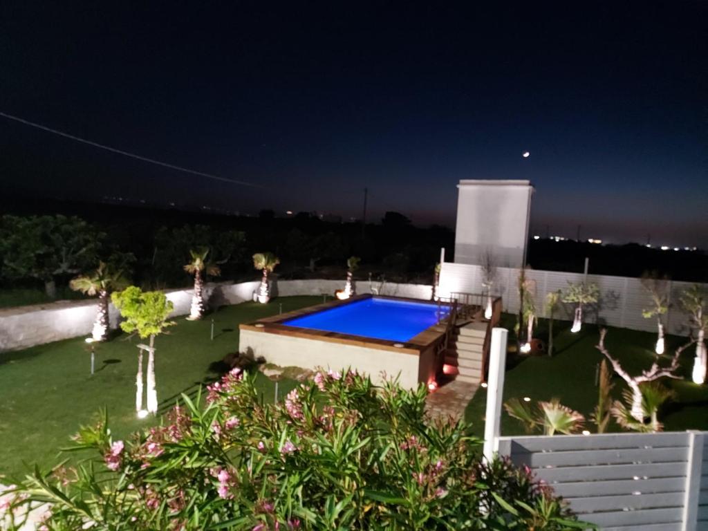 a backyard with a swimming pool at night at Villa Capitani in Torre Canne