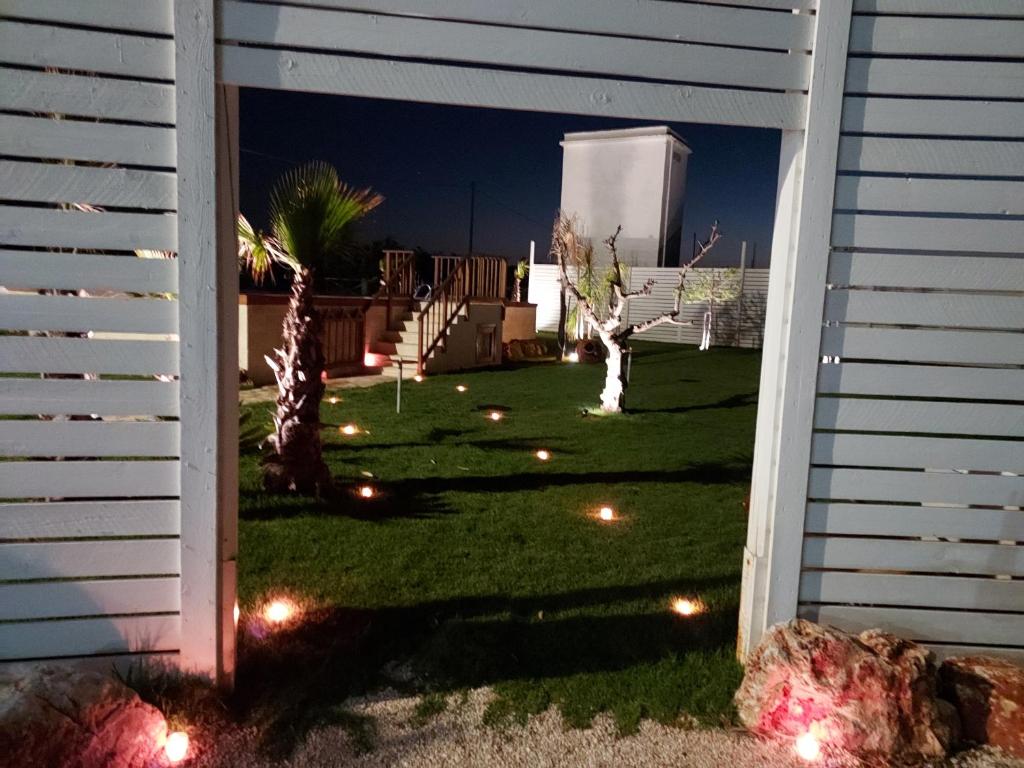 a backyard at night with lights in the grass at Villa Capitani in Torre Canne
