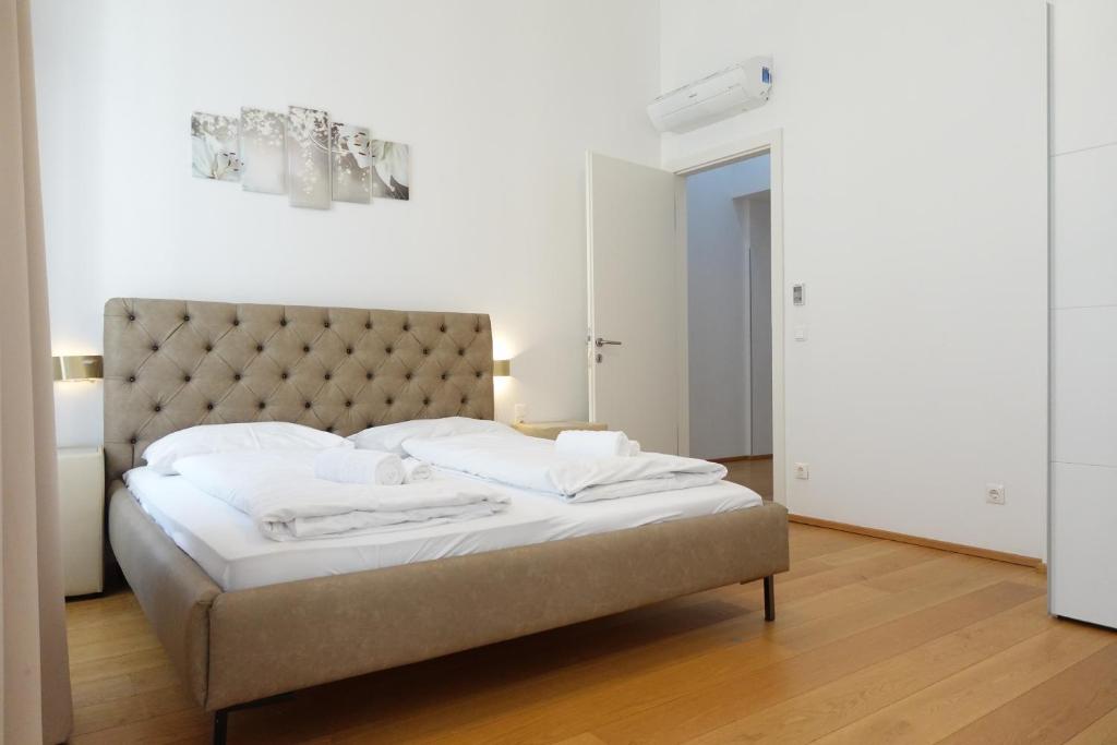 1 dormitorio con 1 cama grande con sábanas blancas en Apartments 4 you Red Star 8, en Viena