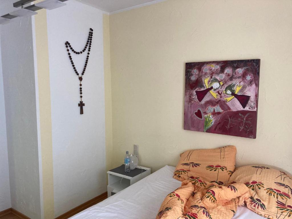 1 dormitorio con 1 cama con una cruz en la pared en Ferienwohnung Katja, en Wilnsdorf