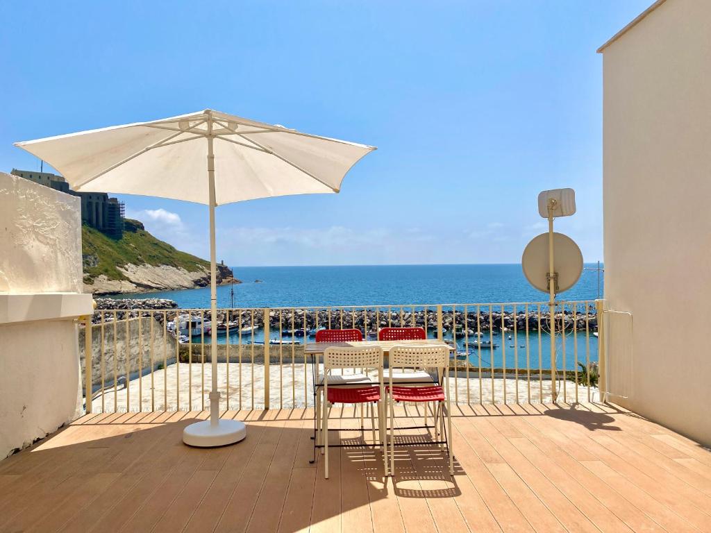 a patio with a table and chairs and an umbrella at "La Terrazza" Corricella in Procida