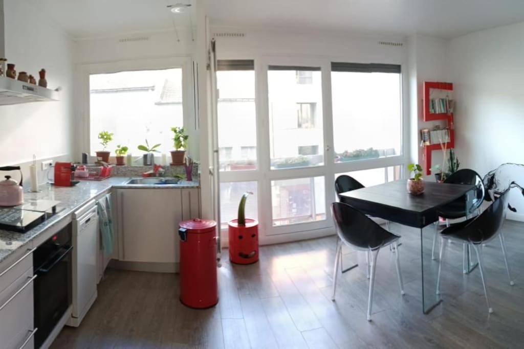 a kitchen with a table and chairs in a room at Appartement Street-art in Paris