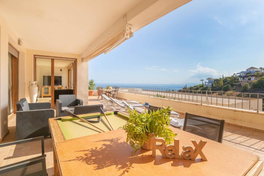 een balkon met een tafel en uitzicht op de oceaan bij Marbella Mountain With Sea View And Pool - Happy Rentals in Marbella