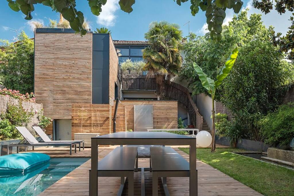 un patio avec une table et des chaises à côté d'une piscine dans l'établissement Maison contemporaine plein centre piscine &jacuzzi, à Toulouse