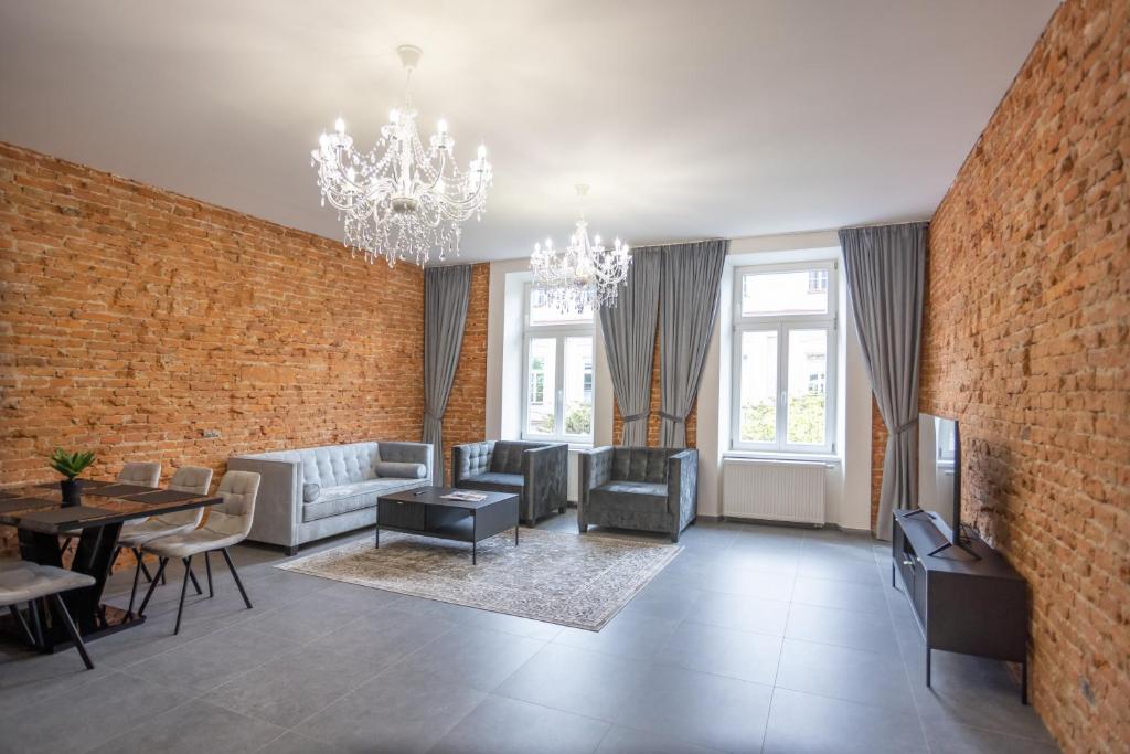 - un grand salon avec un mur en briques dans l'établissement Royal Apartments Liptovsky Mikulas, à Liptovský Mikuláš