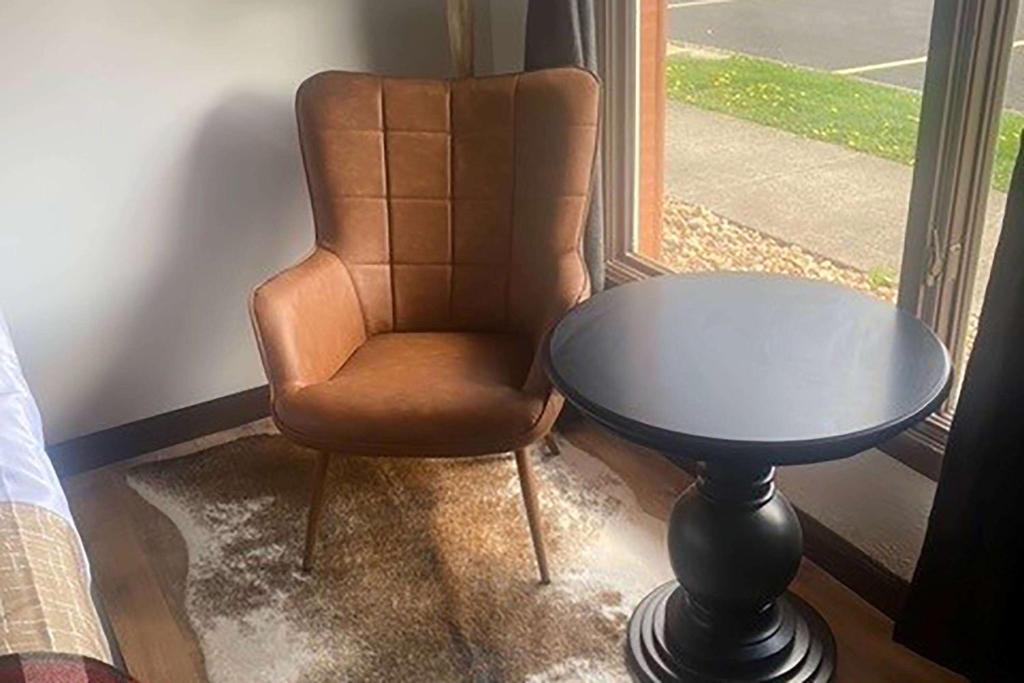 a chair and a table in front of a window at Travelodge by Wyndham Emlenton in Emlenton