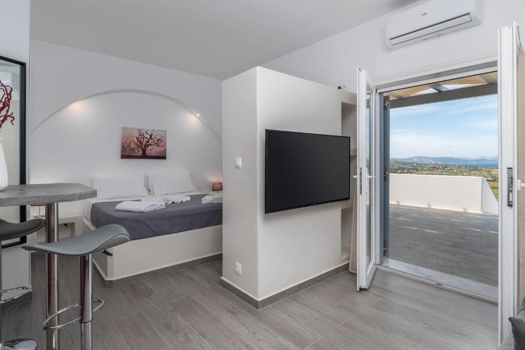 a bedroom with a bed and a flat screen tv at Sunset Village 3 in Paleochori