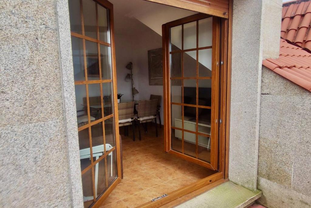 otwarte drzwi do pokoju ze stołem w obiekcie Apartamento Porto do Xufre w mieście Isla de Arosa