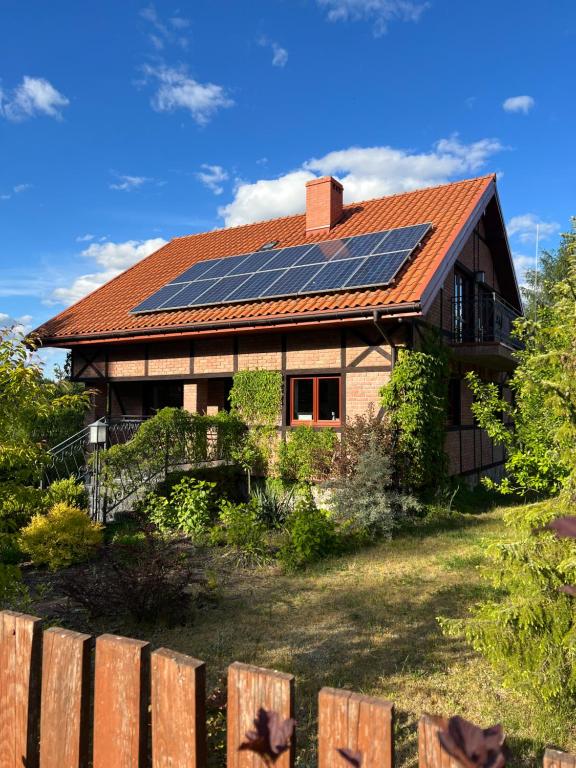 una casa con paneles solares en el techo en Dom pod klonami, en Szczytno