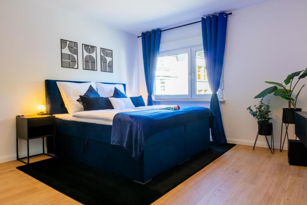 a bedroom with a bed with blue sheets and a window at Uniklinik-Nähe Modernes Apartment, mit Balkon in Wuppertal