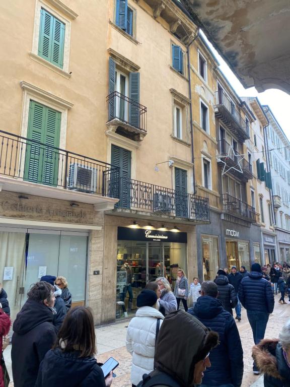 un groupe de personnes debout à l'extérieur d'un bâtiment dans l'établissement Juliet Deluxe Apartment, à Vérone