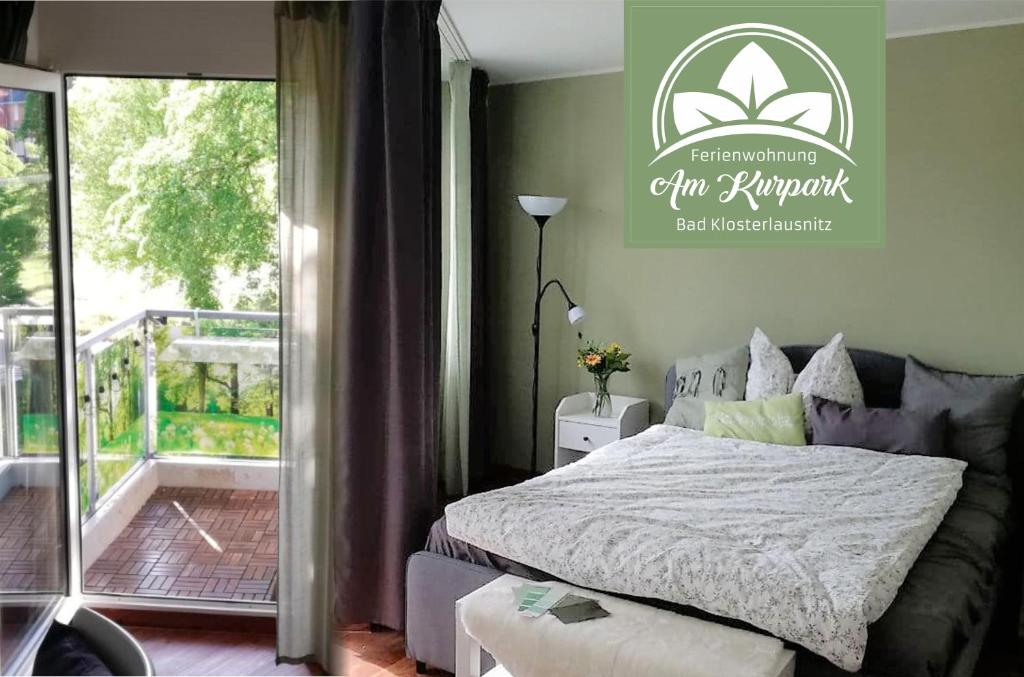 1 dormitorio con 1 cama y balcón en Ferienwohnung Am Kurpark, en Bad Klosterlausnitz
