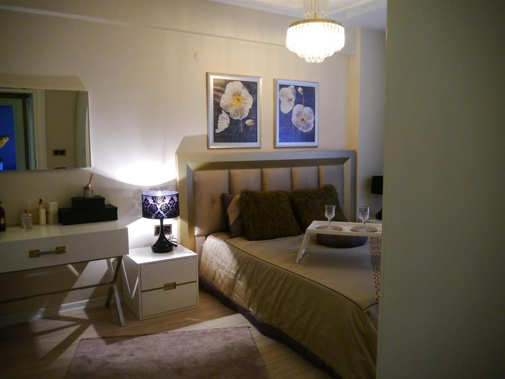 a bedroom with a bed and a table with a lamp at SELAM REZİDANCE BUİLDİNG LUXURY APARTMENT in Hamitler