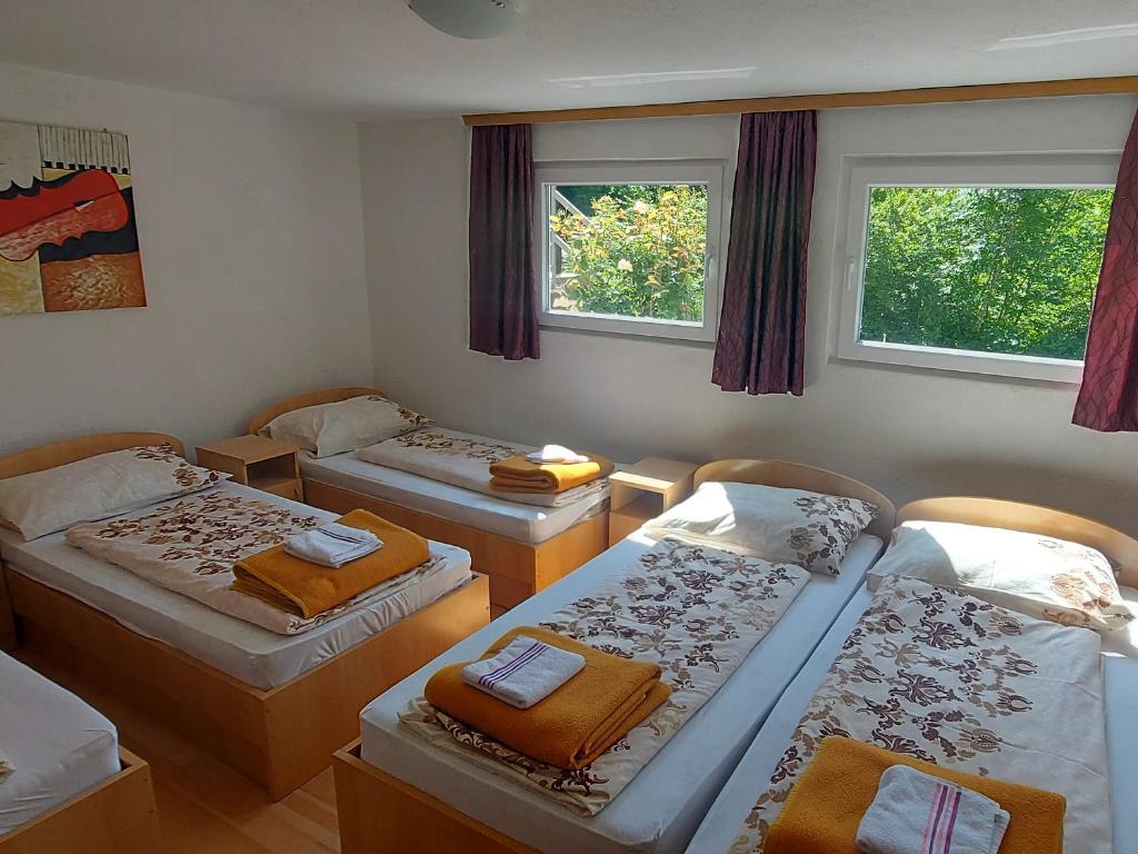 una camera con tre letti e due finestre di VISIT BORACKO LAKE Apartment doelend a Jezero