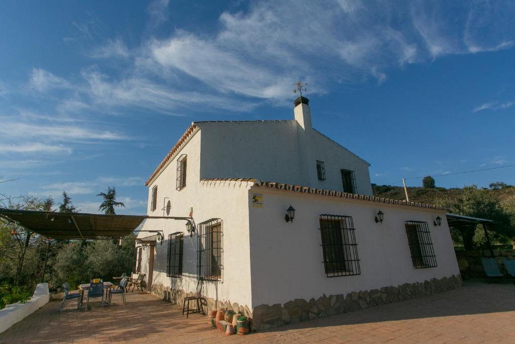 un edificio blanco con una cruz encima en El Cortijuelo de Zalea, en Málaga