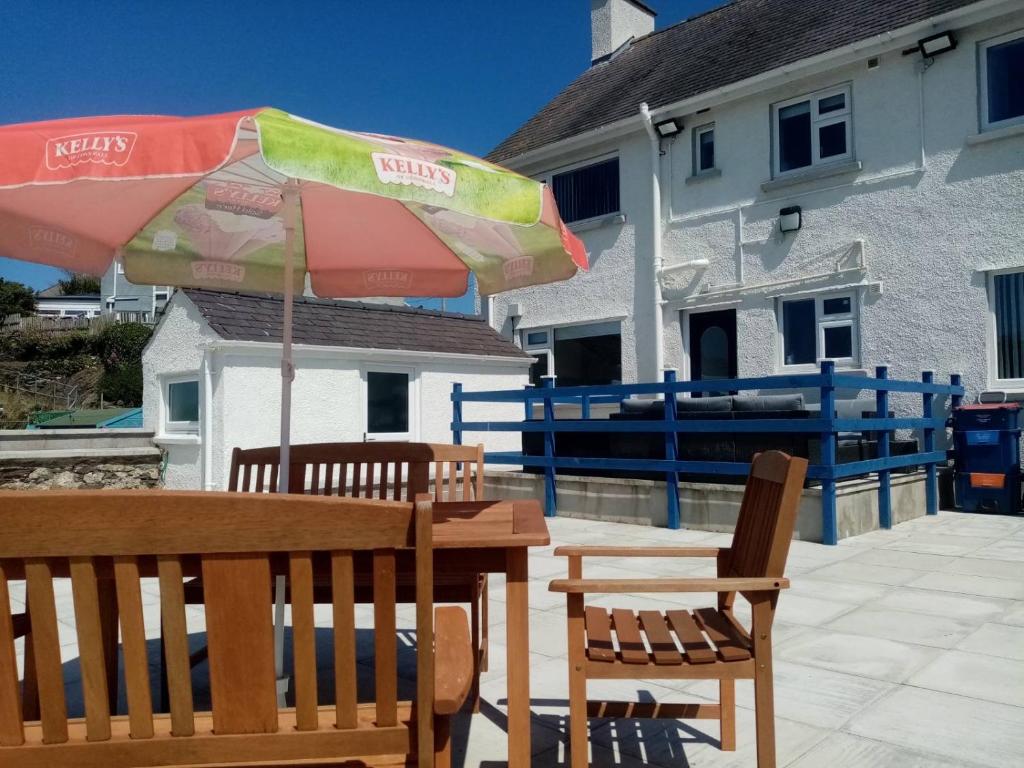 a table and chairs with an umbrella on a patio at Anglesey home by the sea in Amlwch