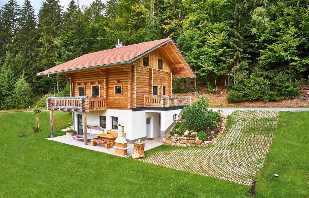 a log cabin with a deck on a lawn at Chalet Blumental in Neuschönau