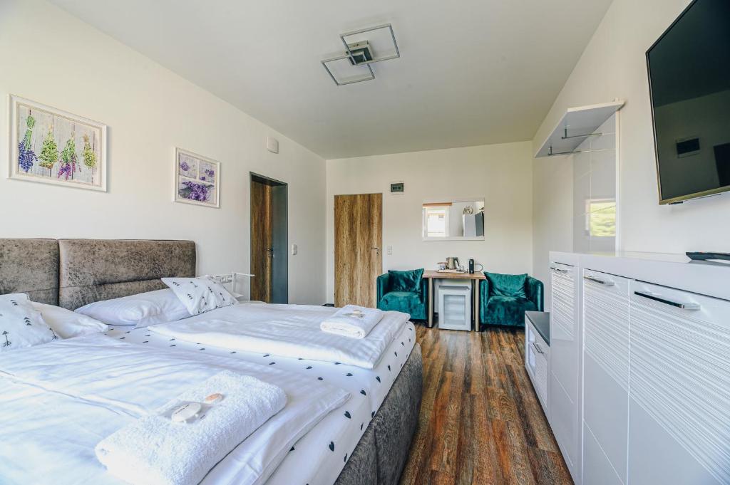 a bedroom with a large bed and a kitchen at Point Pension in Brno