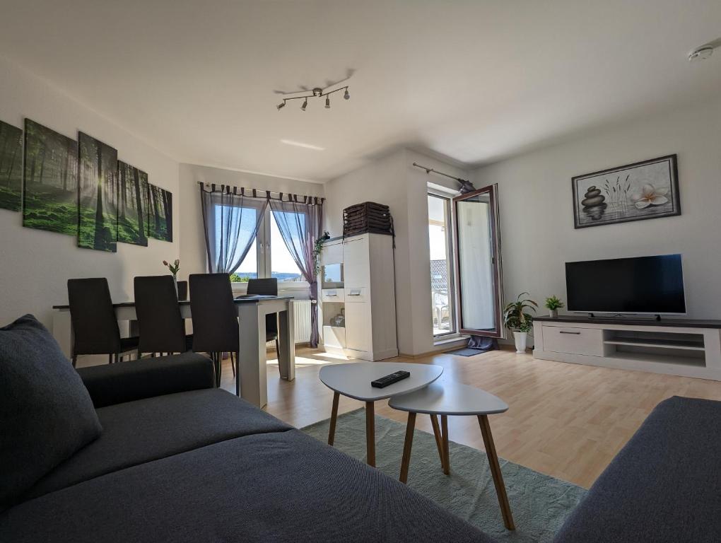 ein Wohnzimmer mit einem Sofa und einem Tisch in der Unterkunft Feldberg Appartement in Neu-Anspach