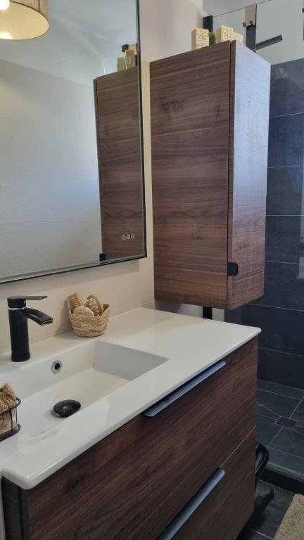 une salle de bain avec un lavabo et un miroir dans l'établissement Martigues centre, à Martigues