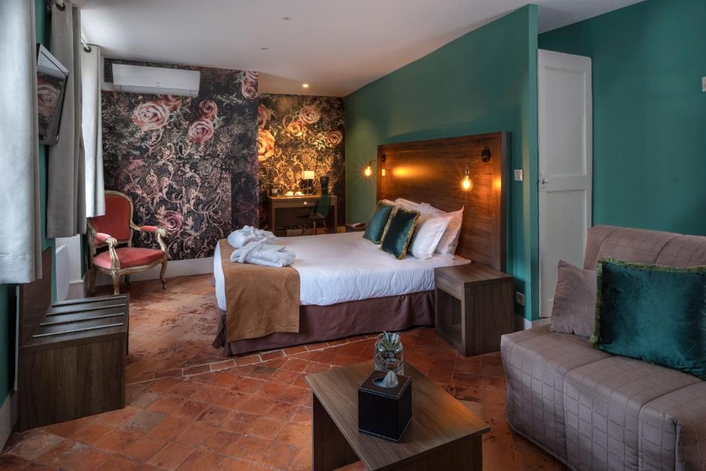 Habitación de hotel con cama y sofá en Hôtel LA MARGELLE en Pernes-les-Fontaines