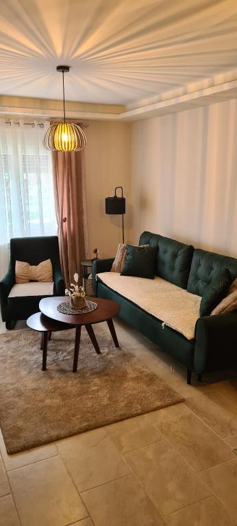 un soggiorno con divano verde e tavolo di Apartman Get Rest a Žabljak