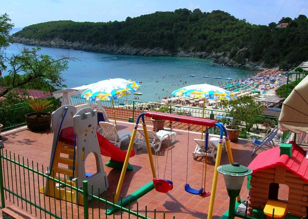 a playground with a beach with people in the water at Hotel Alma in Campo nell'Elba