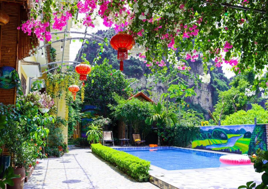 a swimming pool in a garden with red lanterns at Tam Coc Viet Ha Homestay in Ninh Binh