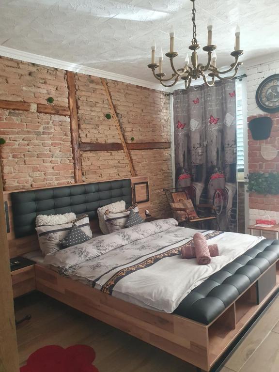 錫比烏的住宿－VintageTrib，砖墙客房内的一张大床