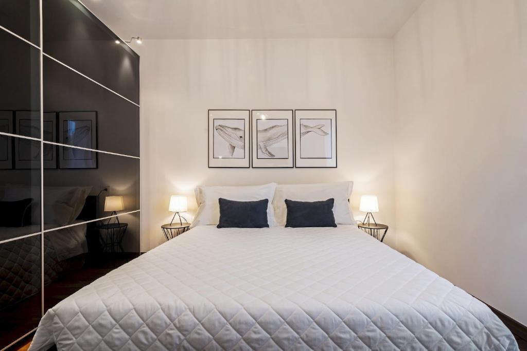a white bedroom with a large bed with two pillows at Martilla in Gabicce Mare