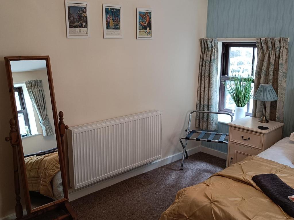 a bedroom with a mirror and a bed and a mirror at Cosy cottage in the heart of Pateley Bridge. in Pateley Bridge