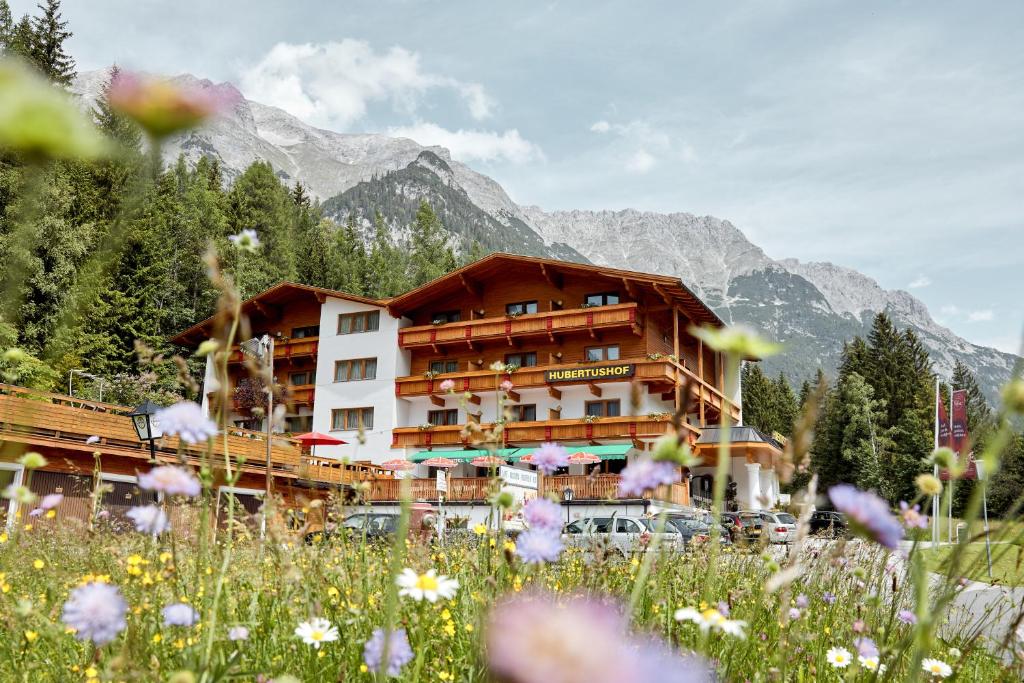 un hotel in montagna con un campo di fiori di Hotel Hubertushof - Ihr Hotel mit Herz a Leutasch