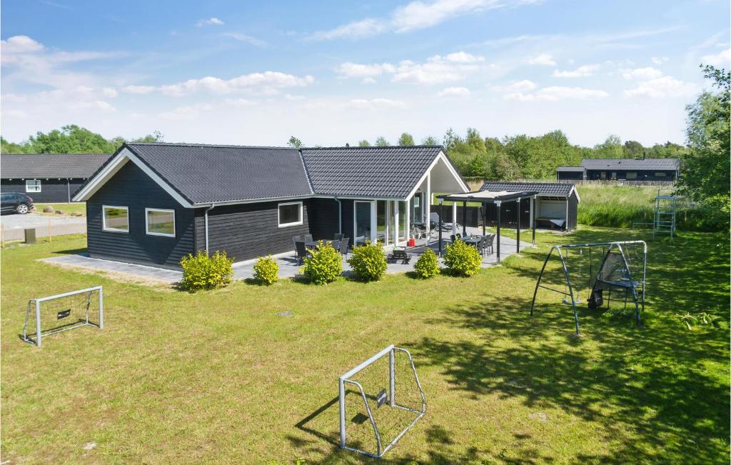 una casa con patio y parque infantil en Beautiful Home In Idestrup With Sauna, en Bøtø By