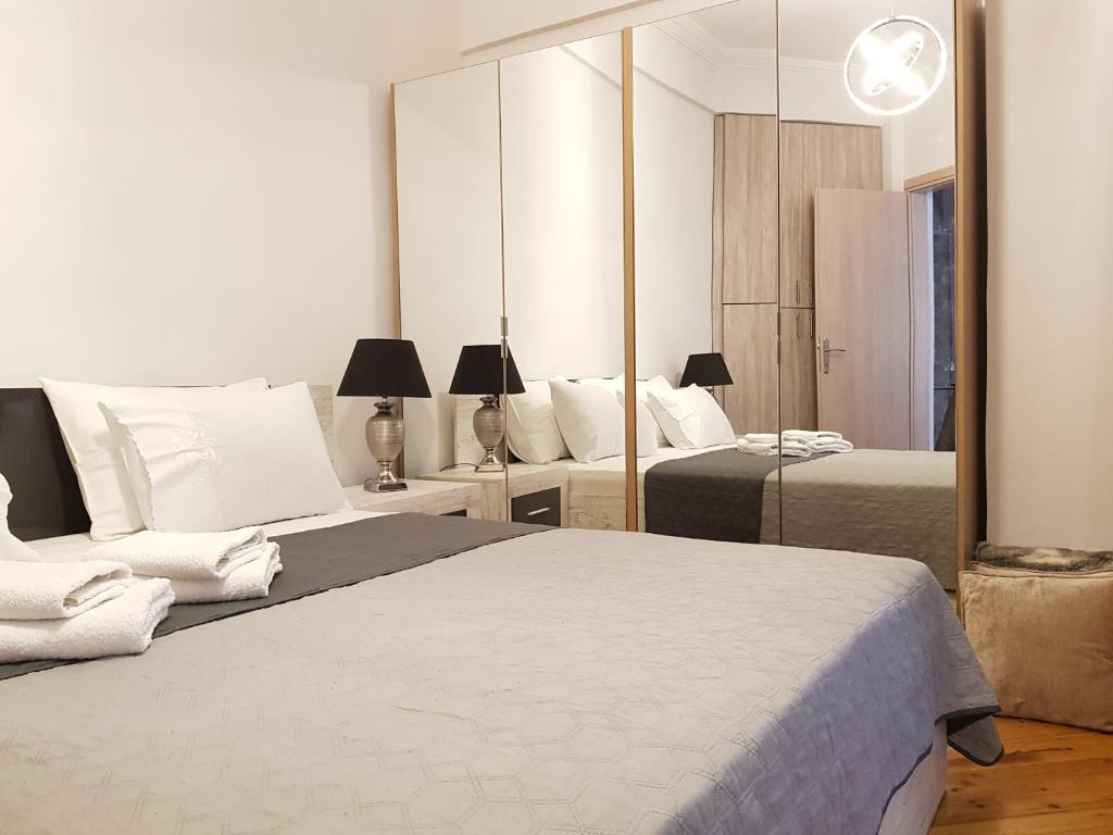 a bedroom with two beds and a mirror at Kabana Suite Thessaloniki in Thessaloniki