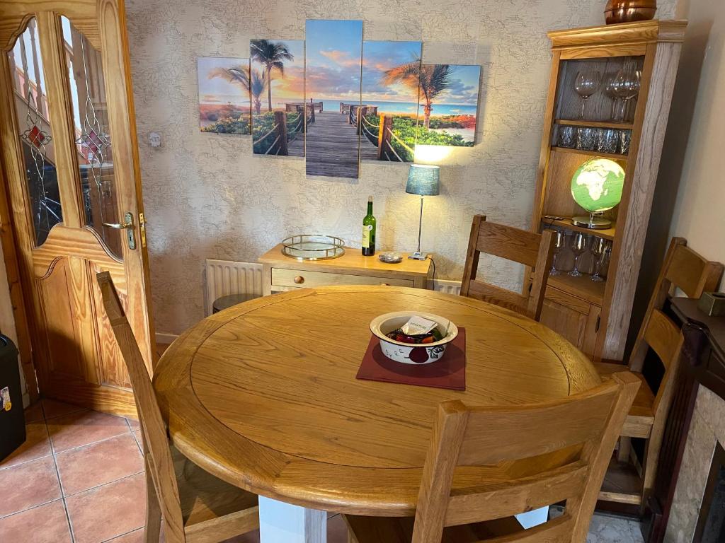 comedor con mesa de madera y sillas en 3 Bed town house 10 min from beach, en Tramore