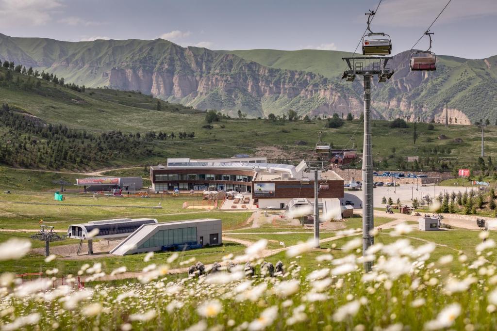 um grupo de autocarros estacionados num campo com uma montanha em Zirve Hotel em Shahdag