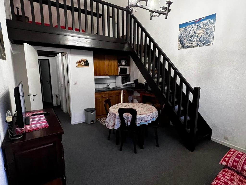 une chambre avec un escalier, une table et une cuisine dans l'établissement Studio lumineux avec mezzanine, balcon, casier à skis et parking à 5 min du centre de Morzine. - FR-1-524-87, à Morzine