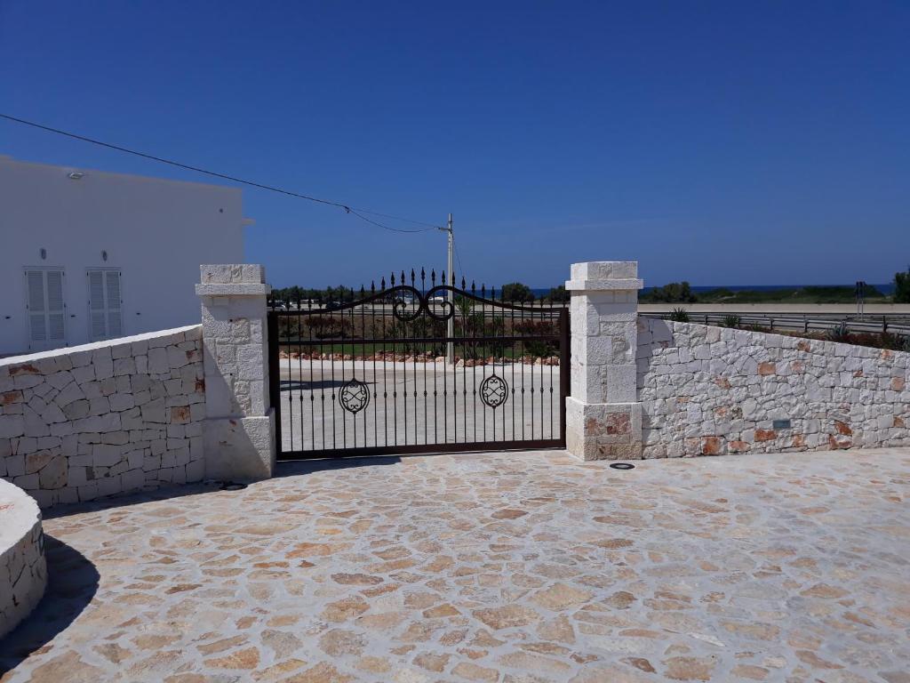 a stone fence with a gate and a stone wall at Villa Capitani in Torre Canne
