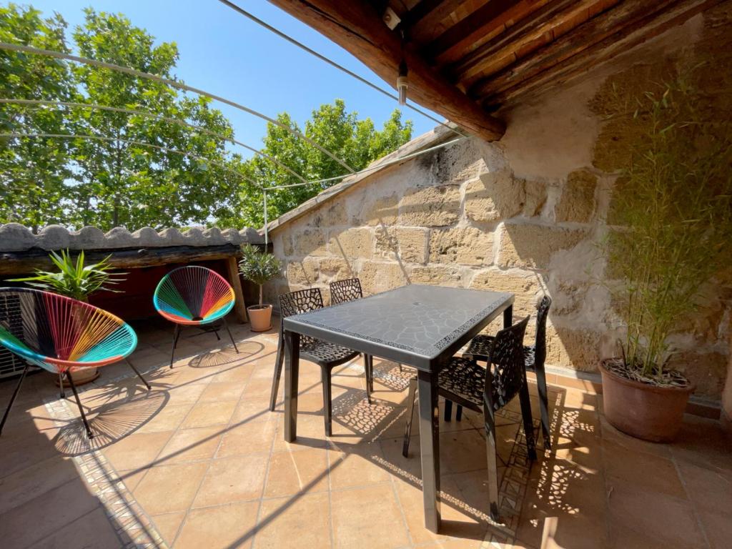 una mesa y sillas en un patio en Spacieux duplex central avec terrasse tropézienne en Salon-de-Provence
