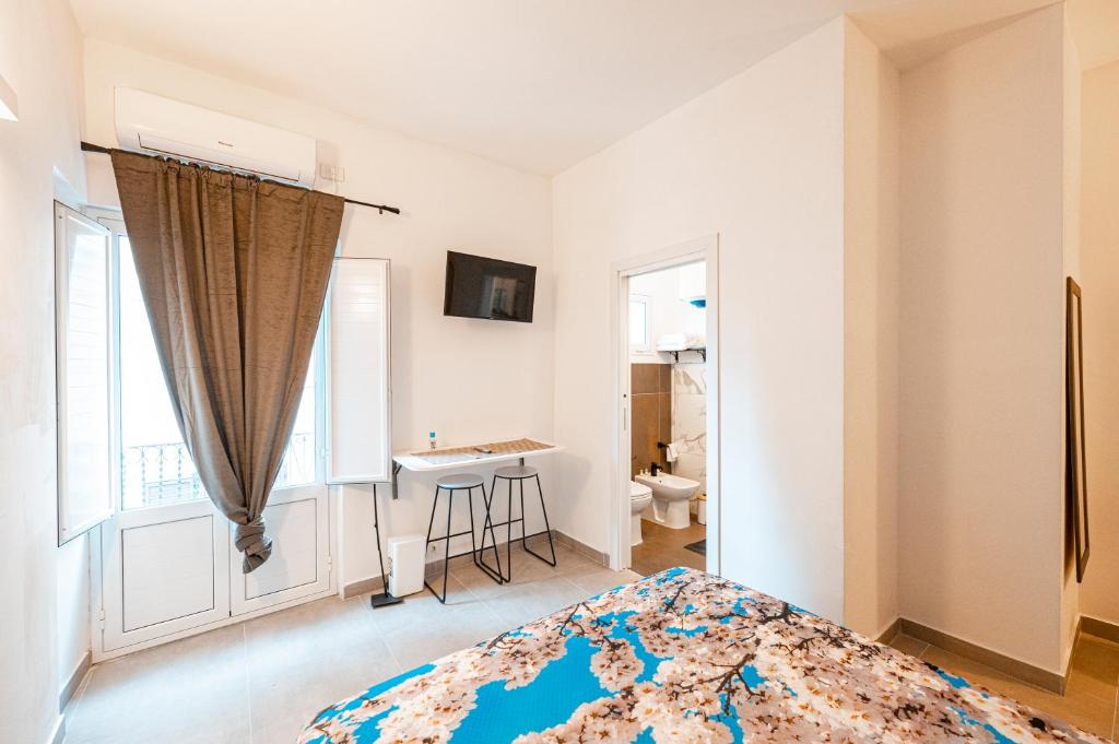CaltabellottaにあるLA MANDORLA Luxury Roomsのベッドルーム1室(ベッド1台、デスク、窓付)