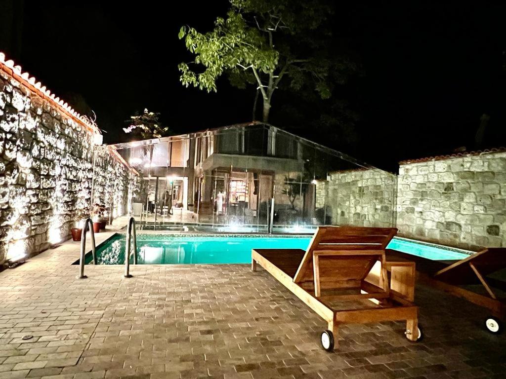a house with a swimming pool at night at Warszawski Alaçatı in Alaçatı